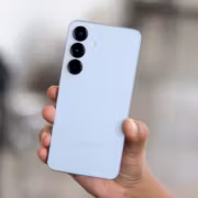 Человек держит белый Samsung Galaxy S25 с тремя камерами