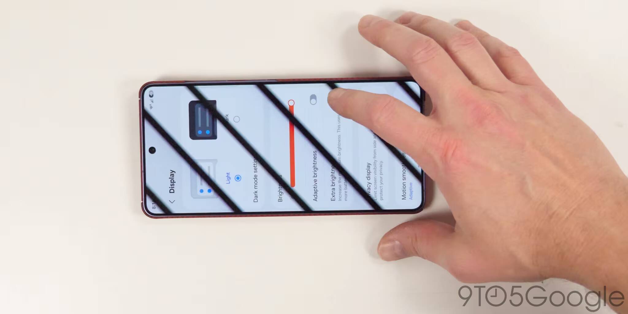 Человек управляет настройками яркости в Galaxy S27 Pro