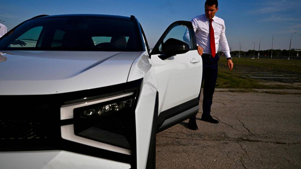 Мужчина в белой рубашке и красном галстуке рядом с белым автомобилем Лада Азимут