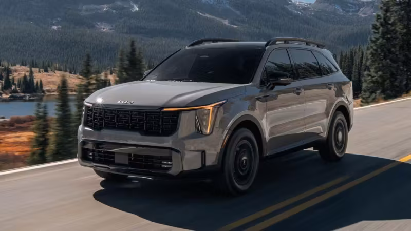 Черный Kia SUV на дороге в горах и лесах