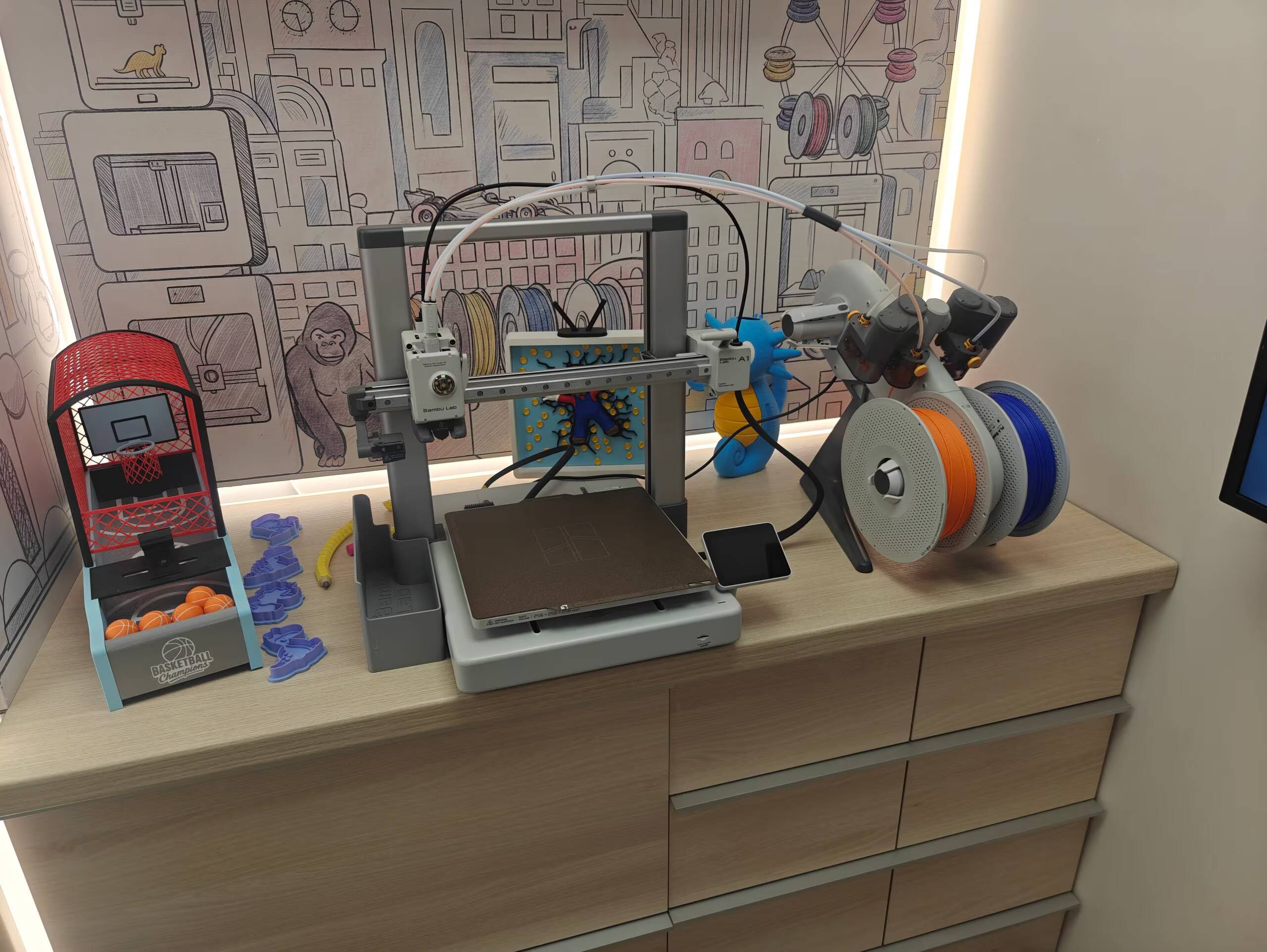 3D-принтер Bambu Lab на столе с катушками и игрушками