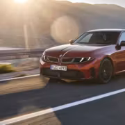 Новая BMW 3 Series едет по дороге на закате