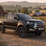 Черный пикап JAC T8 PRO на проселочной дороге в сельской местности
