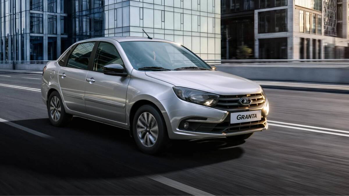 Серебристый седан Lada Granta на городском шоссе