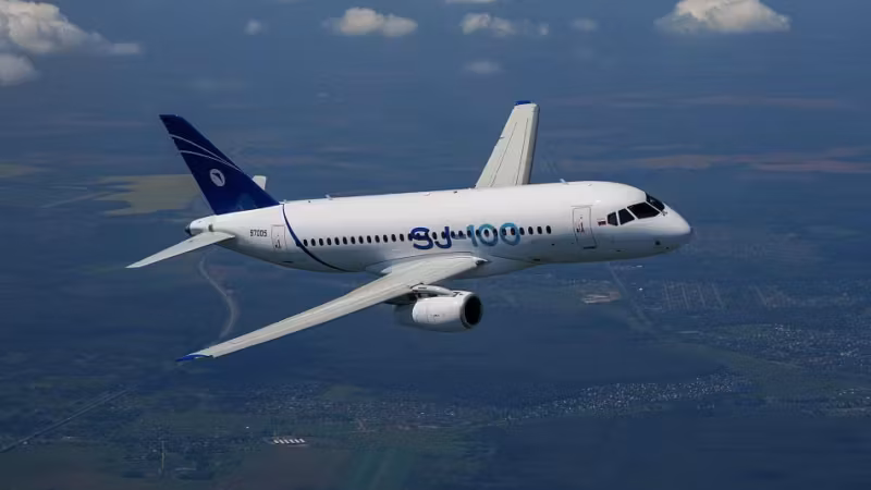 Самолет Sukhoi Superjet-100 в полёте над землёй