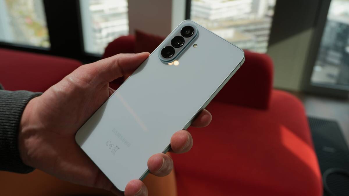 Человек держит белый смартфон Samsung Galaxy A58