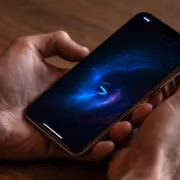 Мужчина держит смартфон Apple iPhone с экраном в космическом стиле