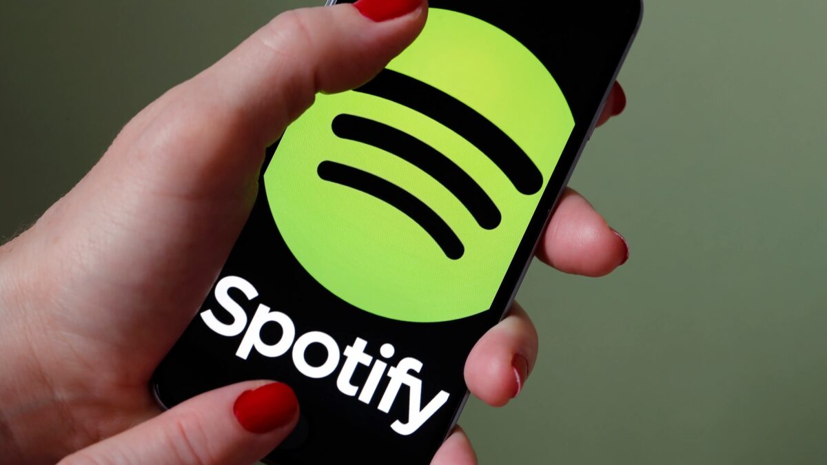 Spotify подтвердила проверку семейной подписки по QR-коду 3 Человек держит смартфон с логотипом Spotify и QR-кодом