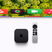 tvOS 27.2 добавит в Apple TV случайный выбор заставок и жестовый язык 5 Apple TV и пульт дистанционного управления на сером фоне