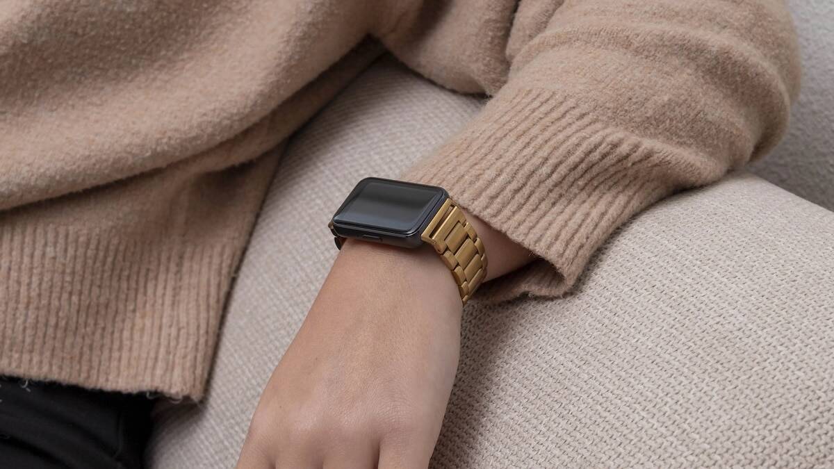 Рука с золотым металлическим браслетом Galaxy Fit4 на запястье